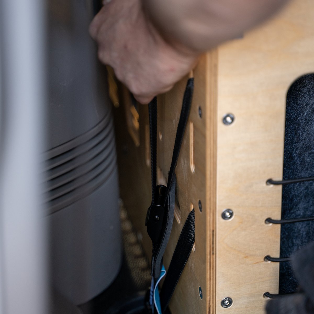 Hand an einem Holzmodul der CampBoks, Detailaufnahme